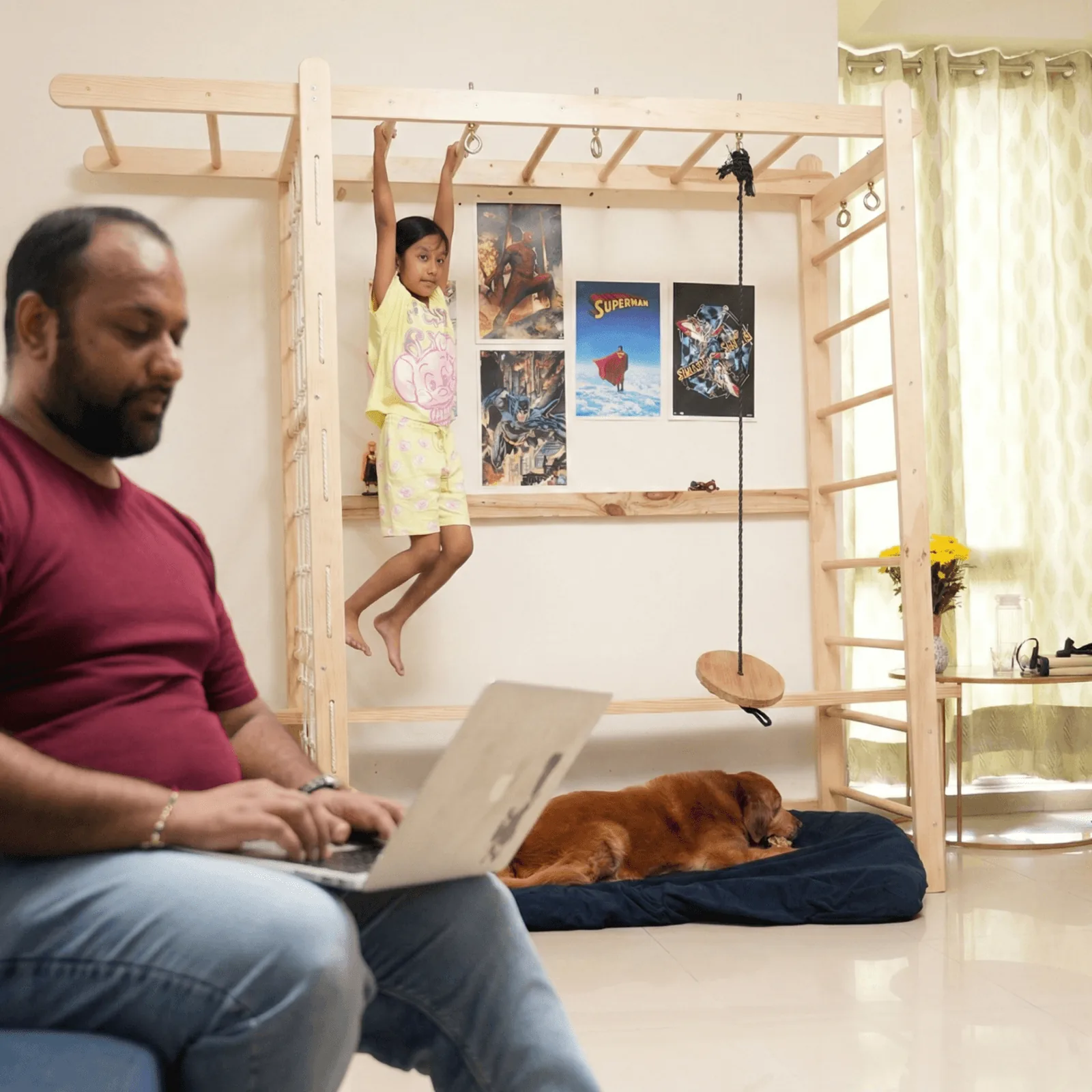 Child doing dead hang on Titan Tower with pet dog relaxing